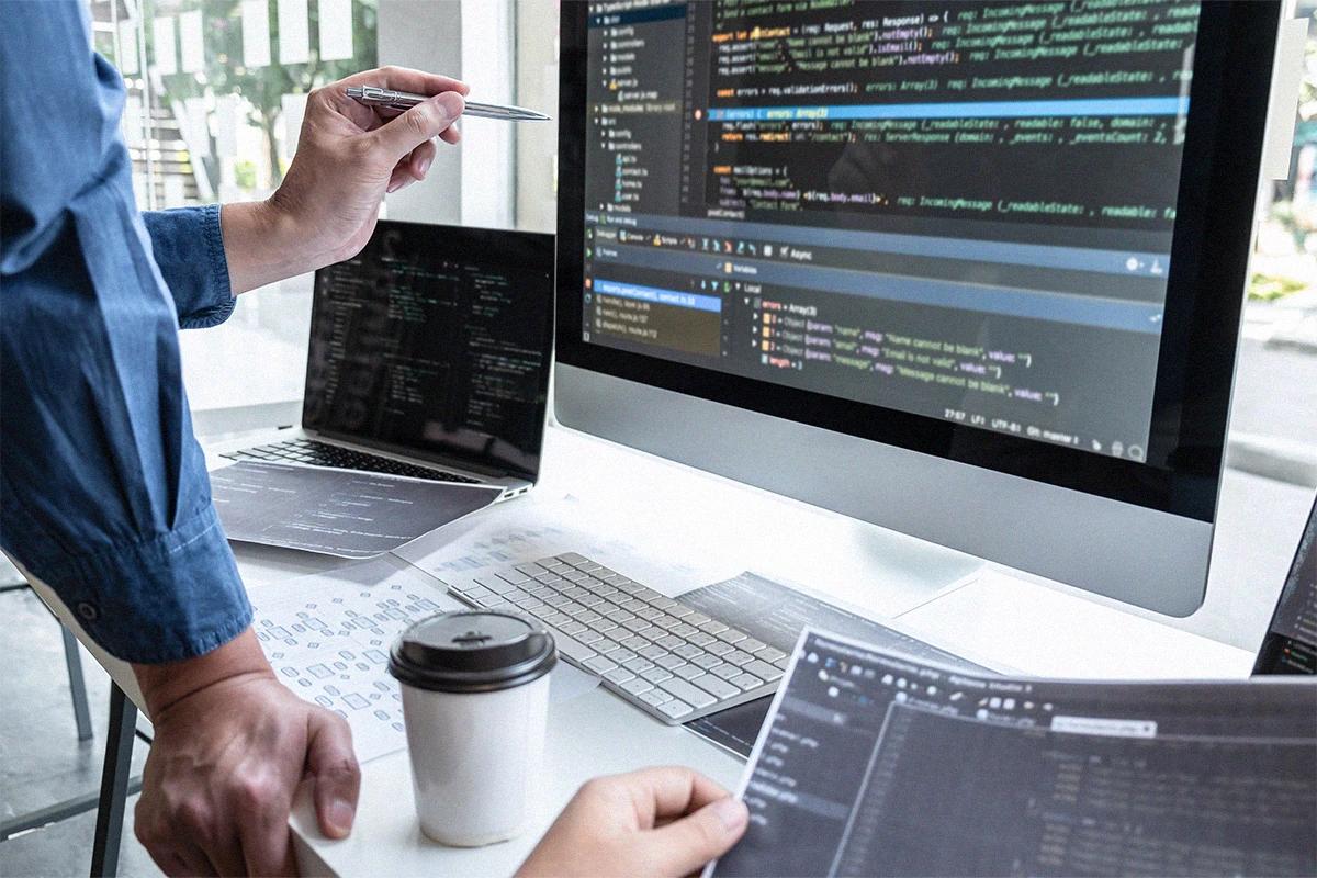 Web development meeting with code on screens