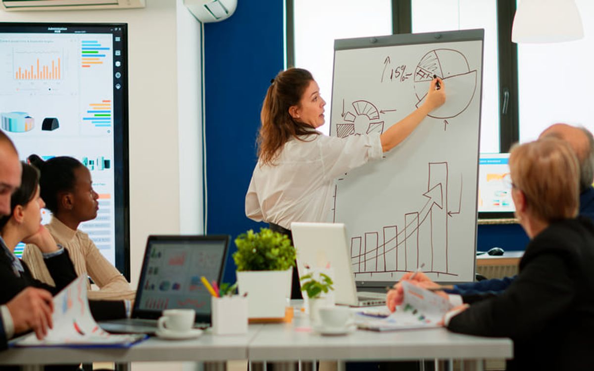 Equipo empresarial revisando un plan estratégico con gráficos de crecimiento y análisis de mercado durante una presentación profesional Hiweb