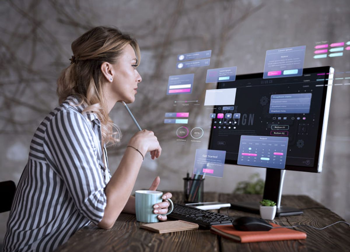 Diseñadora analizando una interfaz digital con elementos de experiencia de usuario en un monitor Hiweb