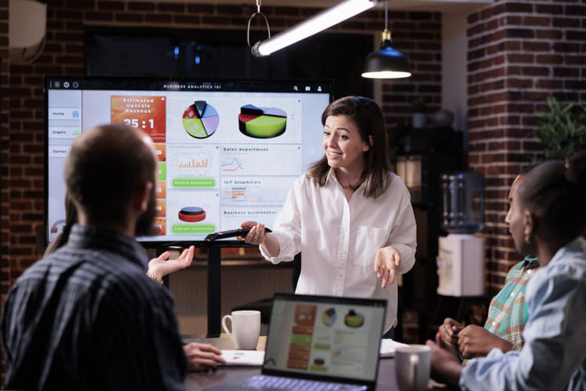 Equipo empresarial durante una presentación mostrando analítica de ventas y métricas de crecimiento en una reunión de estrategia de marketing Hiweb