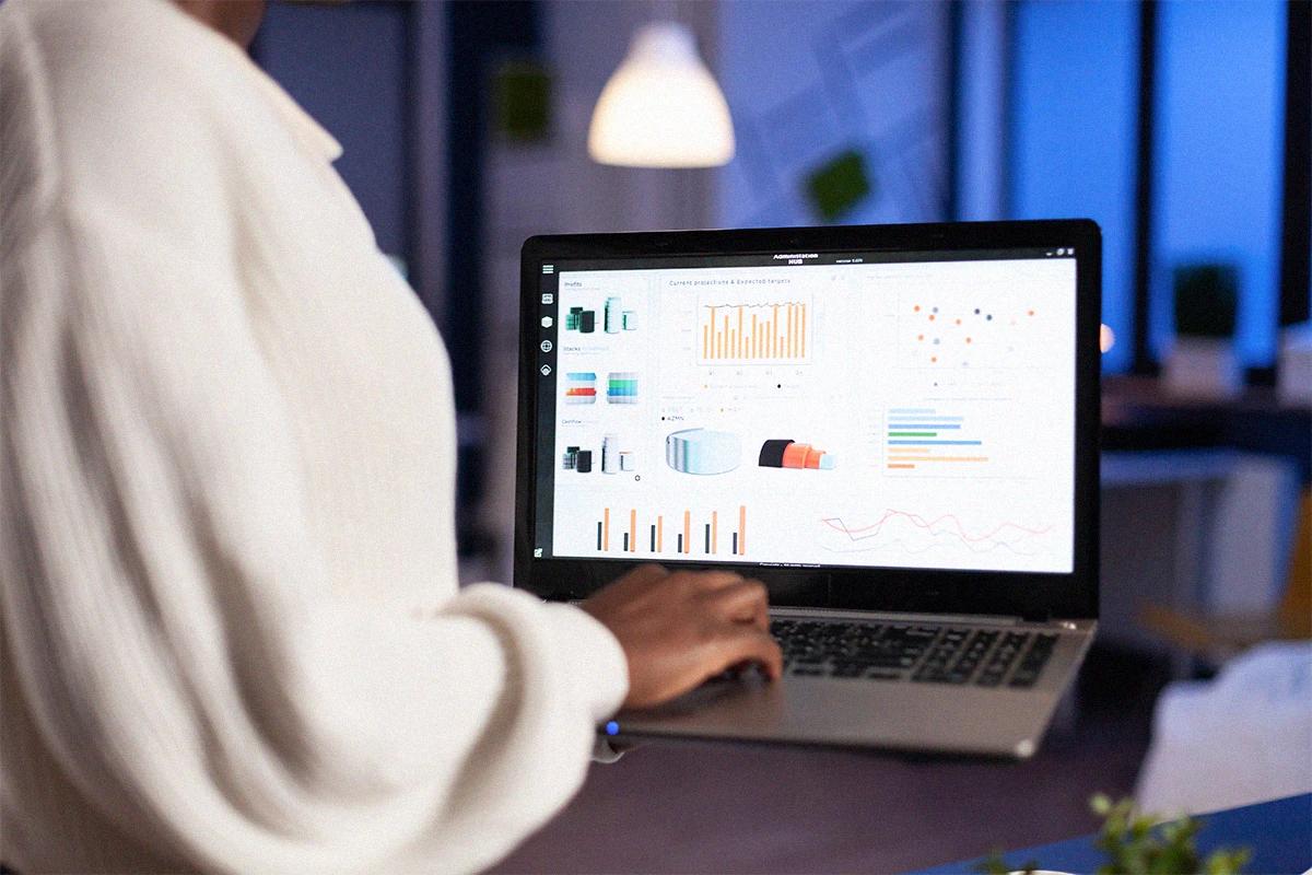 Professional reviewing digital charts and reports on a computer to analyze performance and improve business strategies Hiweb.