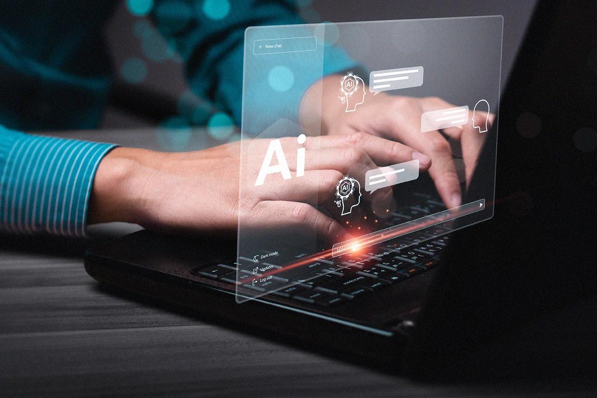 Manos escribiendo en una laptop con un badge de una conversación con Inteligencia artificial