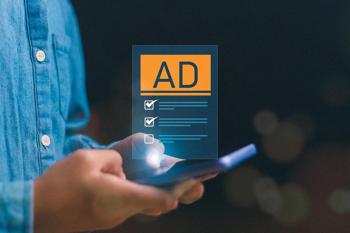 Person using a tablet while managing a digital advertising campaign through an ad interface
