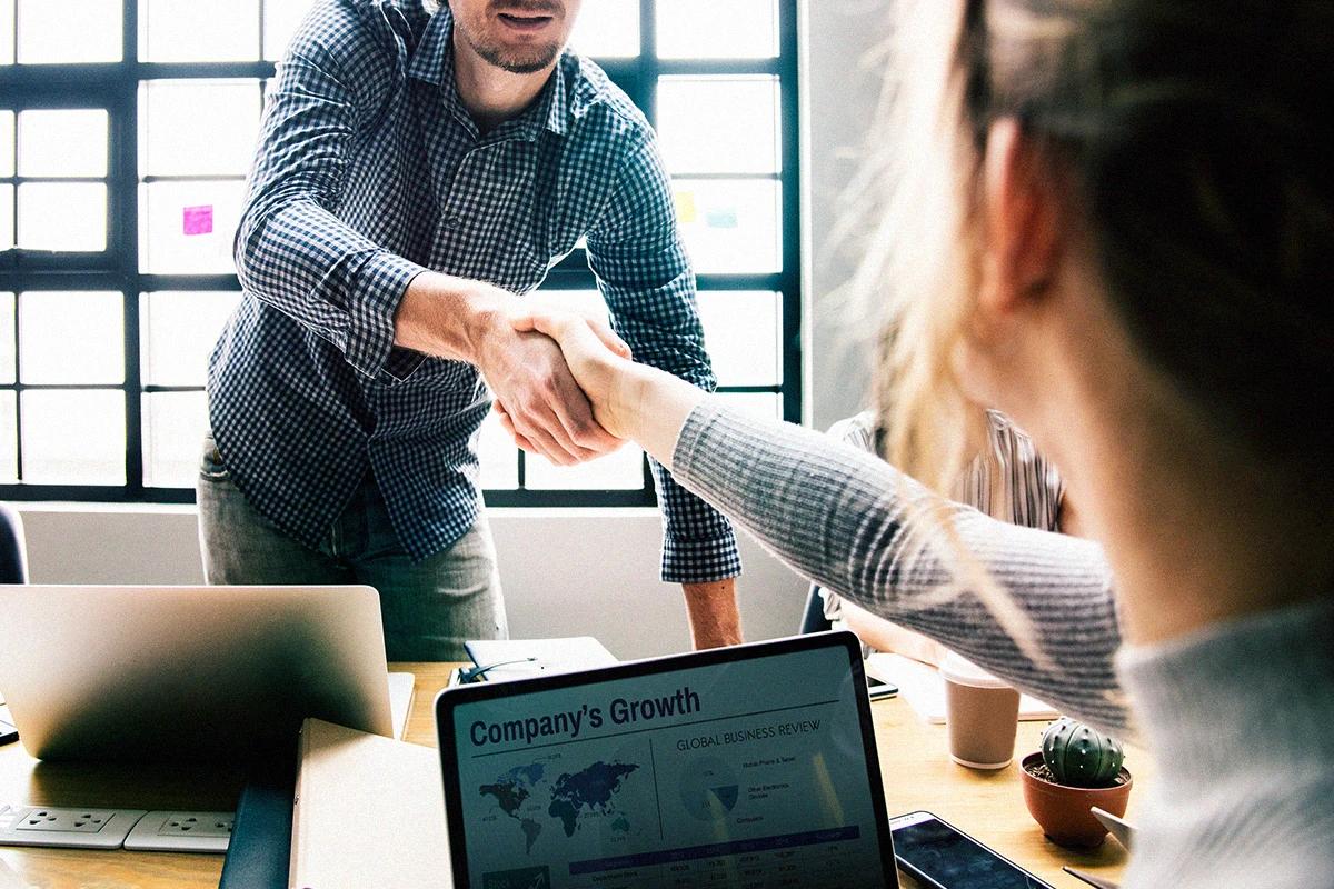 Professionals collaborating in a business meeting with growth charts and strategic analysis to strengthen digital and commercial processes Hiweb.