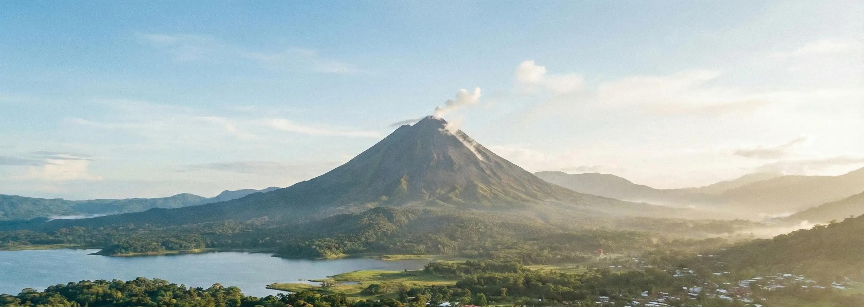 Arenal Volcano viewed from a rainforest trail with clear visibility and surrounding lush vegetation.