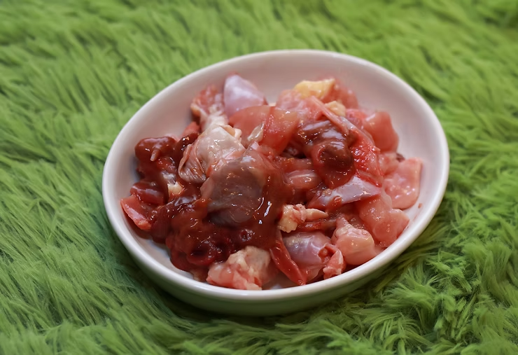 A bowl of raw fresh chicken meat and intestines.