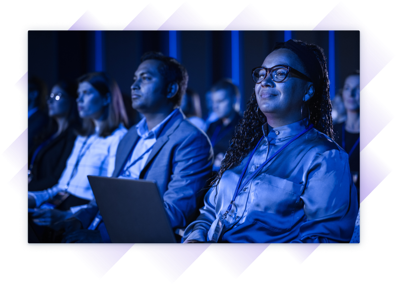 Group of professionals attentively watching a presentation at a training event.