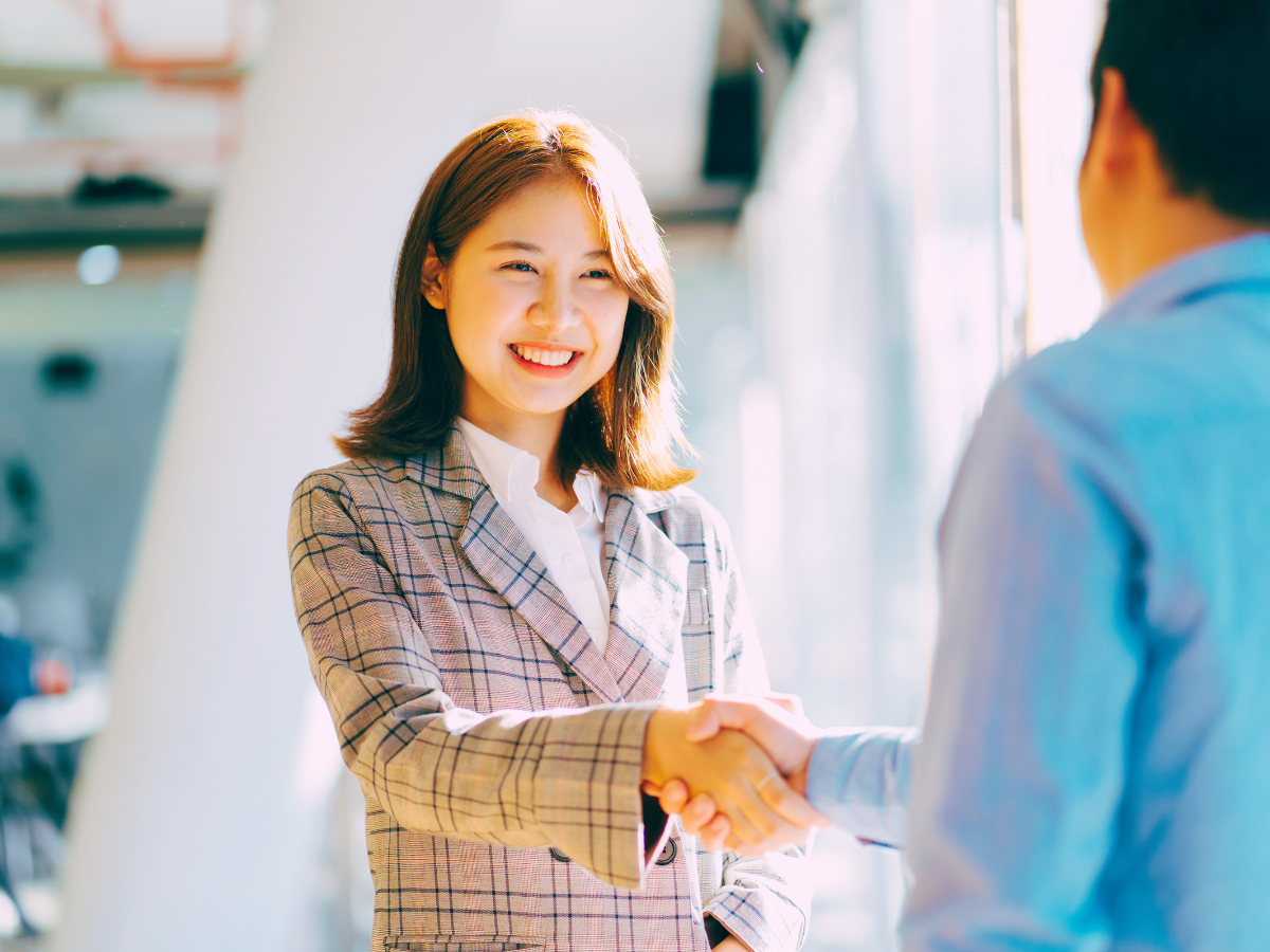 man and woman shake hands in an office
