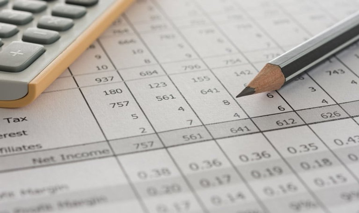 Close-up of a financial spreadsheet with a pencil and calculator, showing rows of numerical data including tax and net income figures.