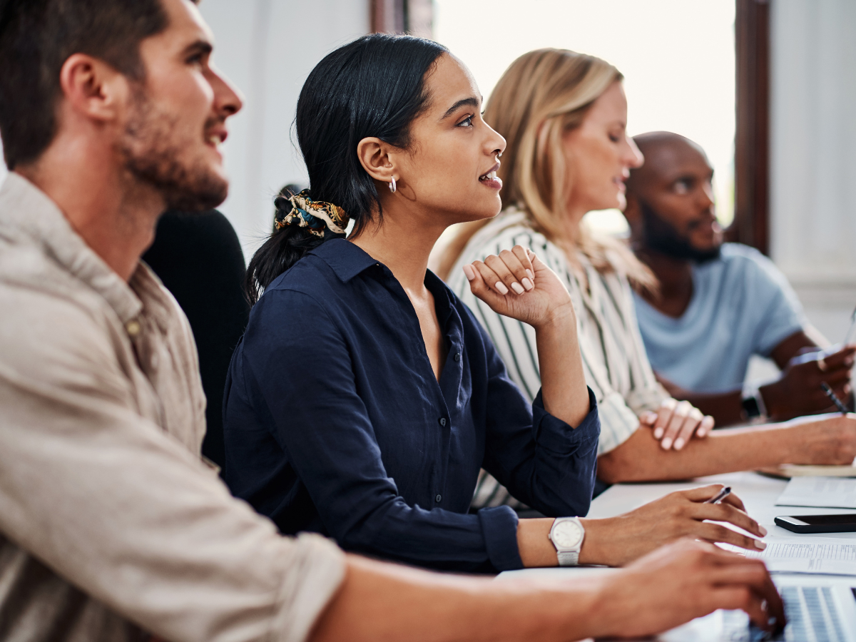 People in a corporate training session smiling and engaging with instructor led training.