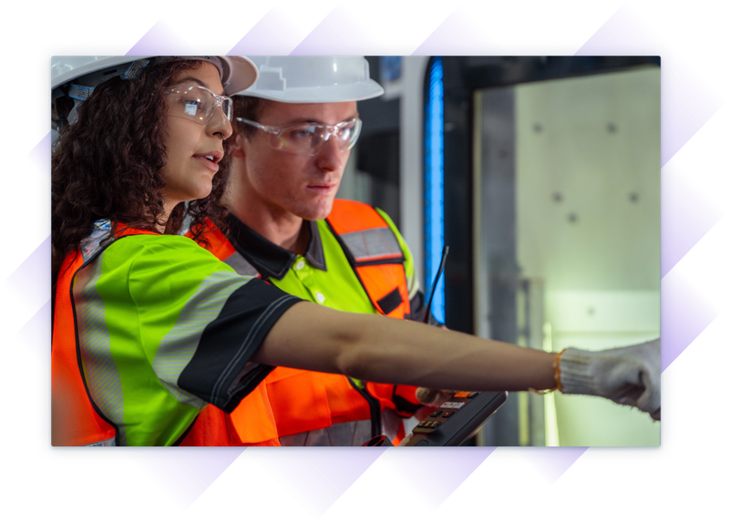 Two engineers in safety gear reviewing equipment controls and inspecting machinery.