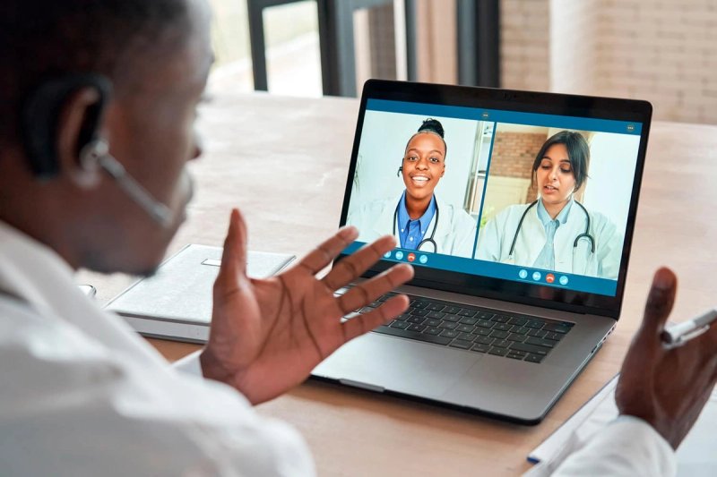 Doctor on a video call with other doctors gesticulating as he speaks.