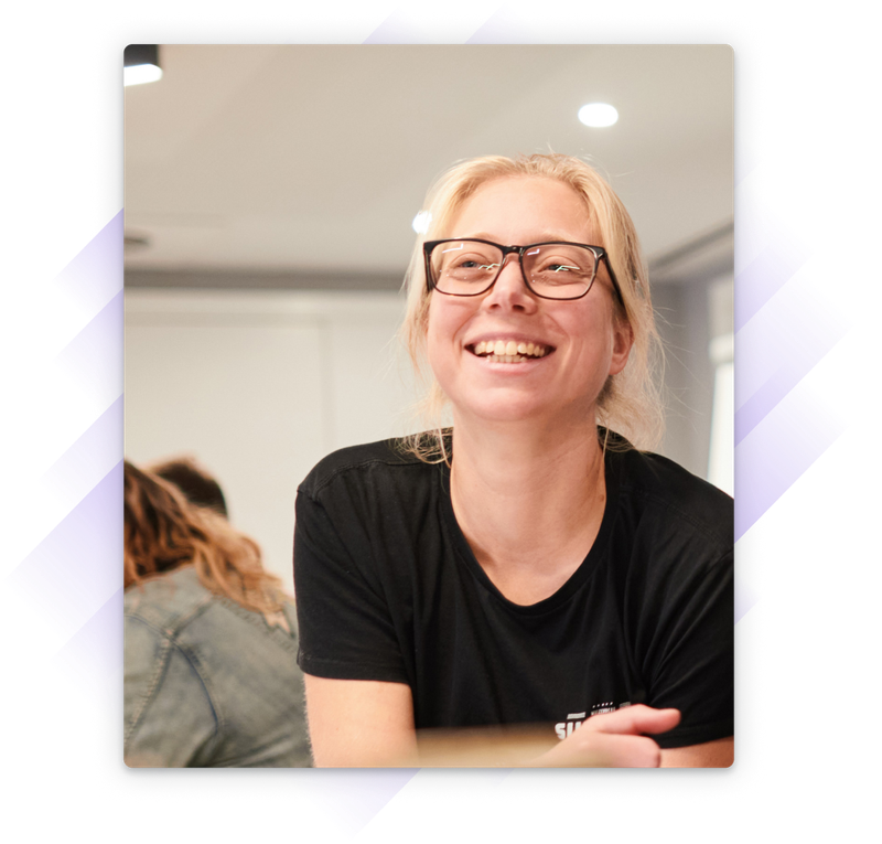 Smiling blonde woman in a conference room smiling up to their right.