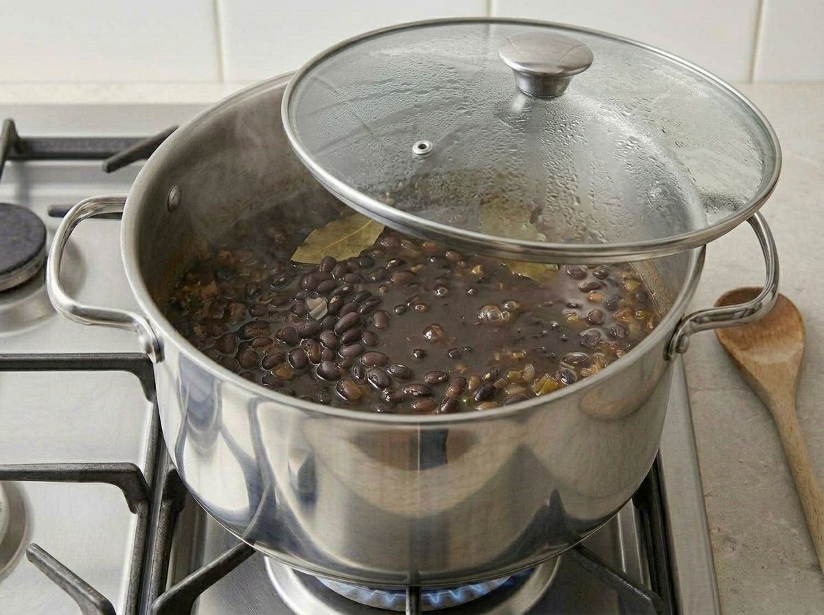 The soup simmering gently under a glass lid set askew, the surface barely moving