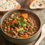 Hearty vegan lentil soup garnished with fresh parsley in a bowl.