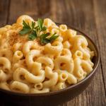 Creamy vegan mac and cheese topped with parsley in a brown bowl.