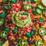 Vegan nachos topped with spicy cashew cheese, black beans, and jalapeños.
