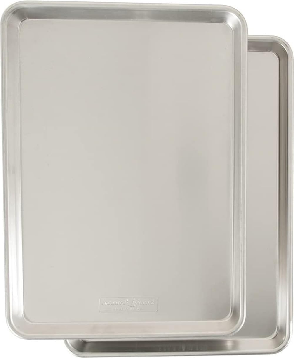 Two natural aluminum rimmed baking sheets stacked at an angle