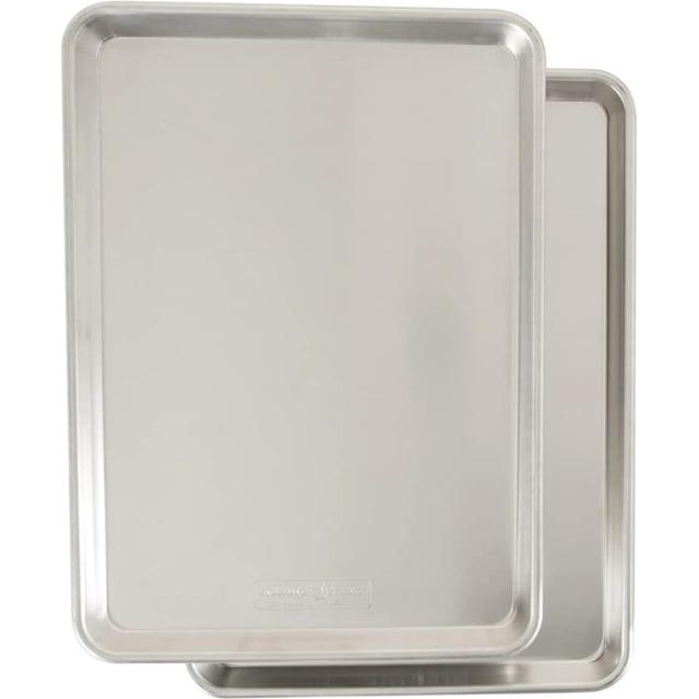 Two natural aluminum rimmed baking sheets stacked at an angle