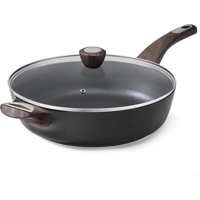 Deep black non-stick skillet with a glass lid and wood-effect handles