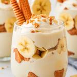 Vegan banana pudding in a jar, topped with vanilla wafers and coconut.