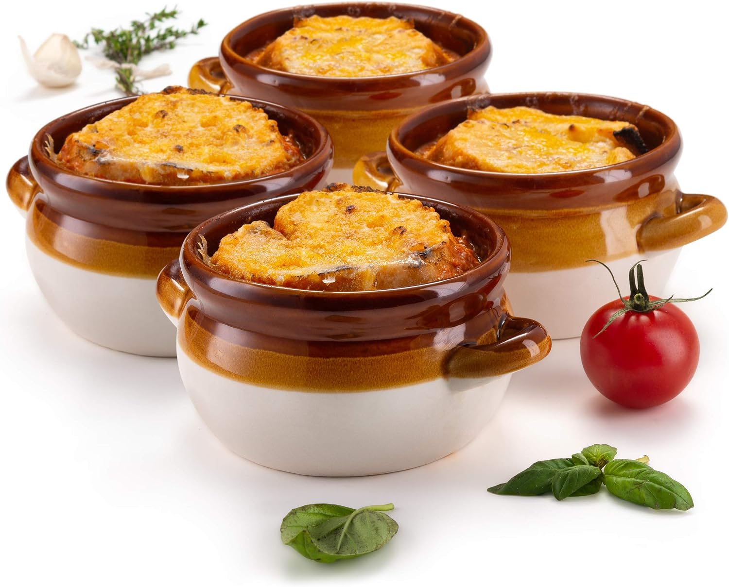 Four two-toned brown and cream stoneware soup crocks with small side handles, each filled with French onion soup under a browned cheese topped round of bread