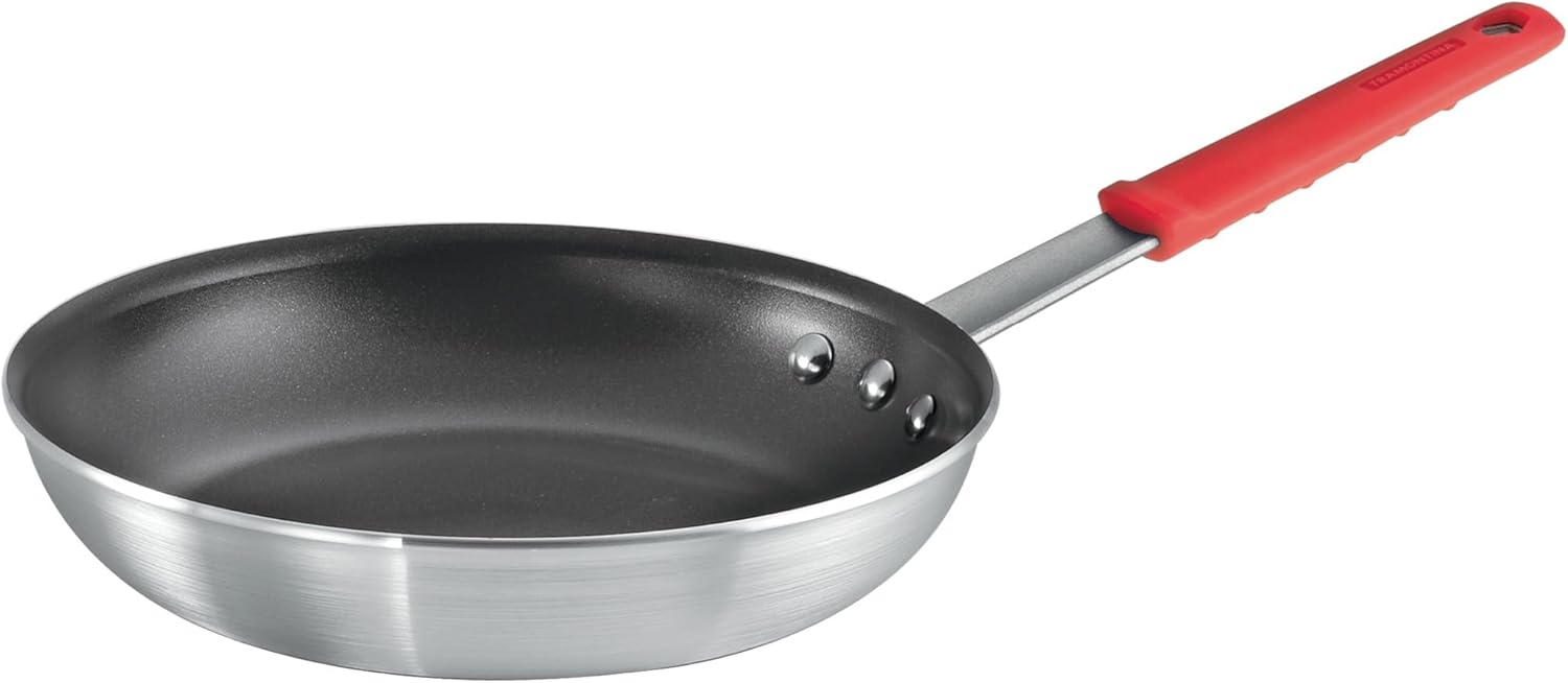 Aluminum frying pan with a black non-stick interior and a red silicone handle grip