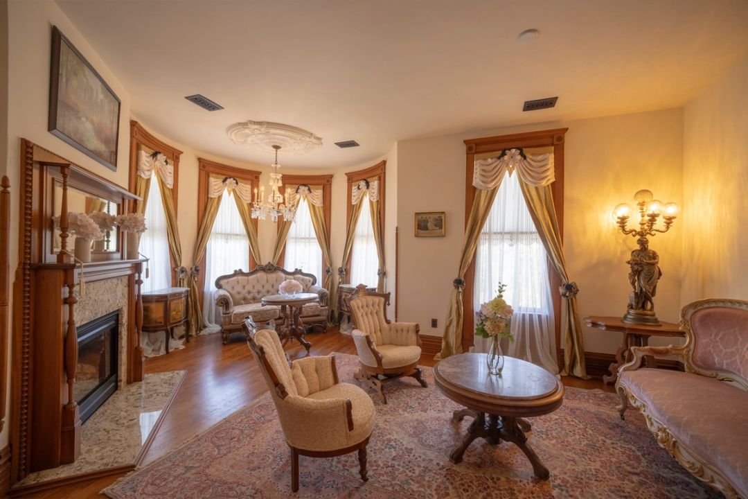 The Grand Cuvée Suite, a parlor with antique sofas, armchairs and a fireplace