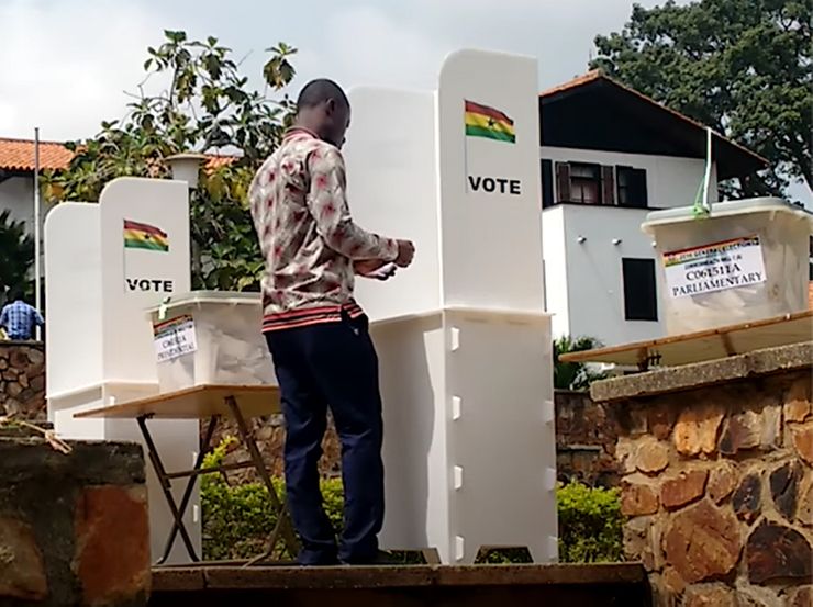 A young man voting at a voting booth