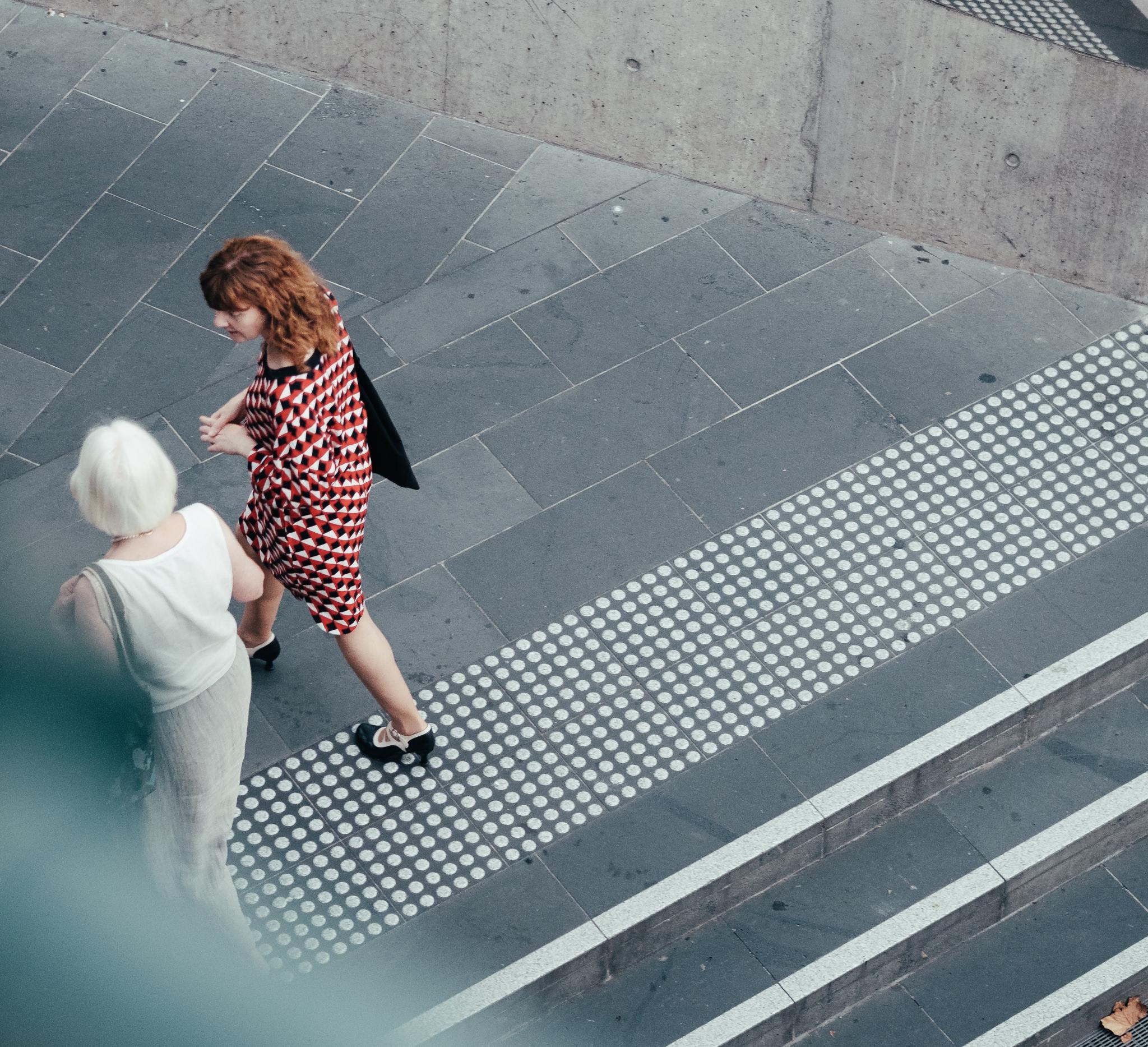 Two women walk down stairs