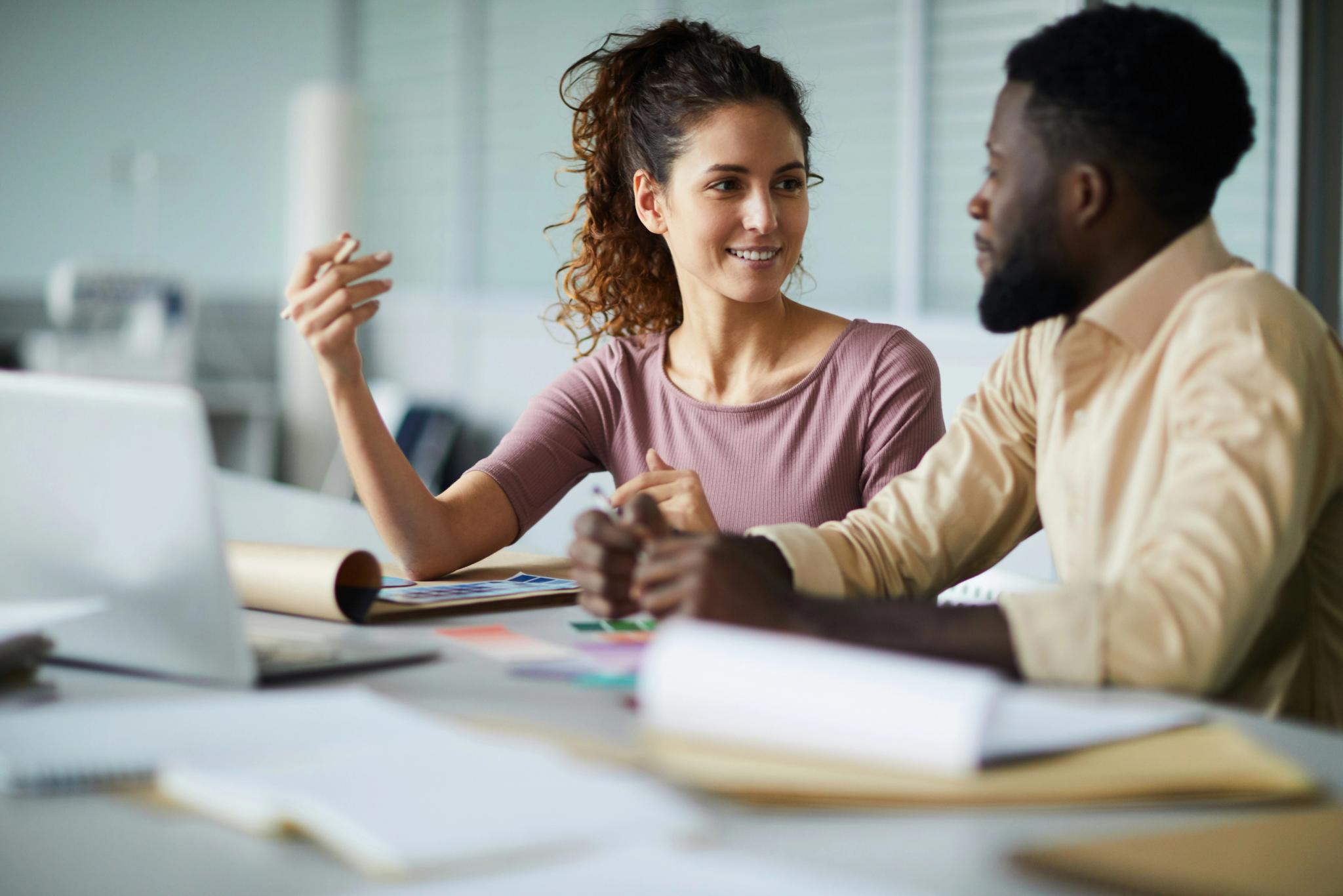 Two people at a desk discuss important things