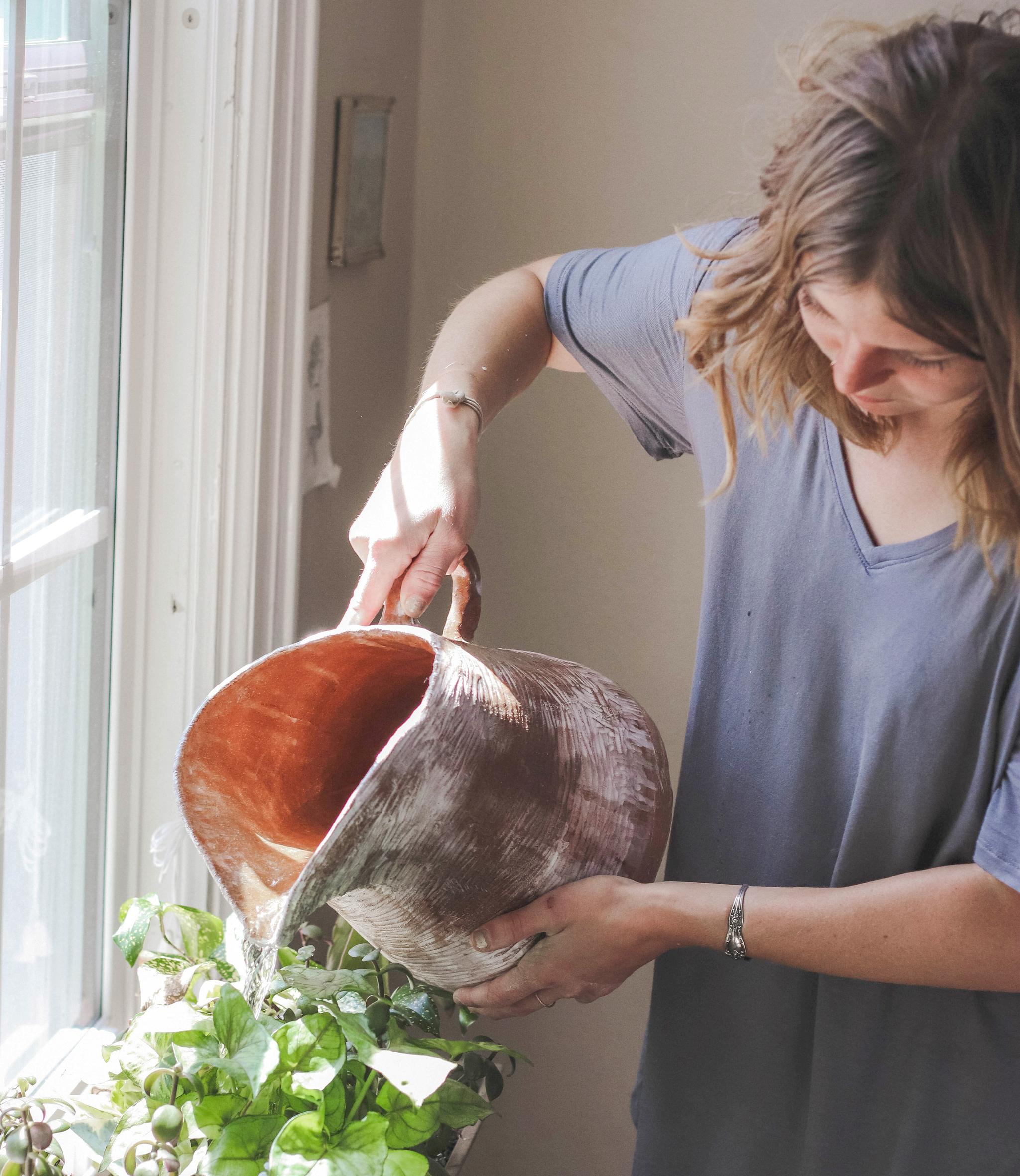 A woman waters her plants