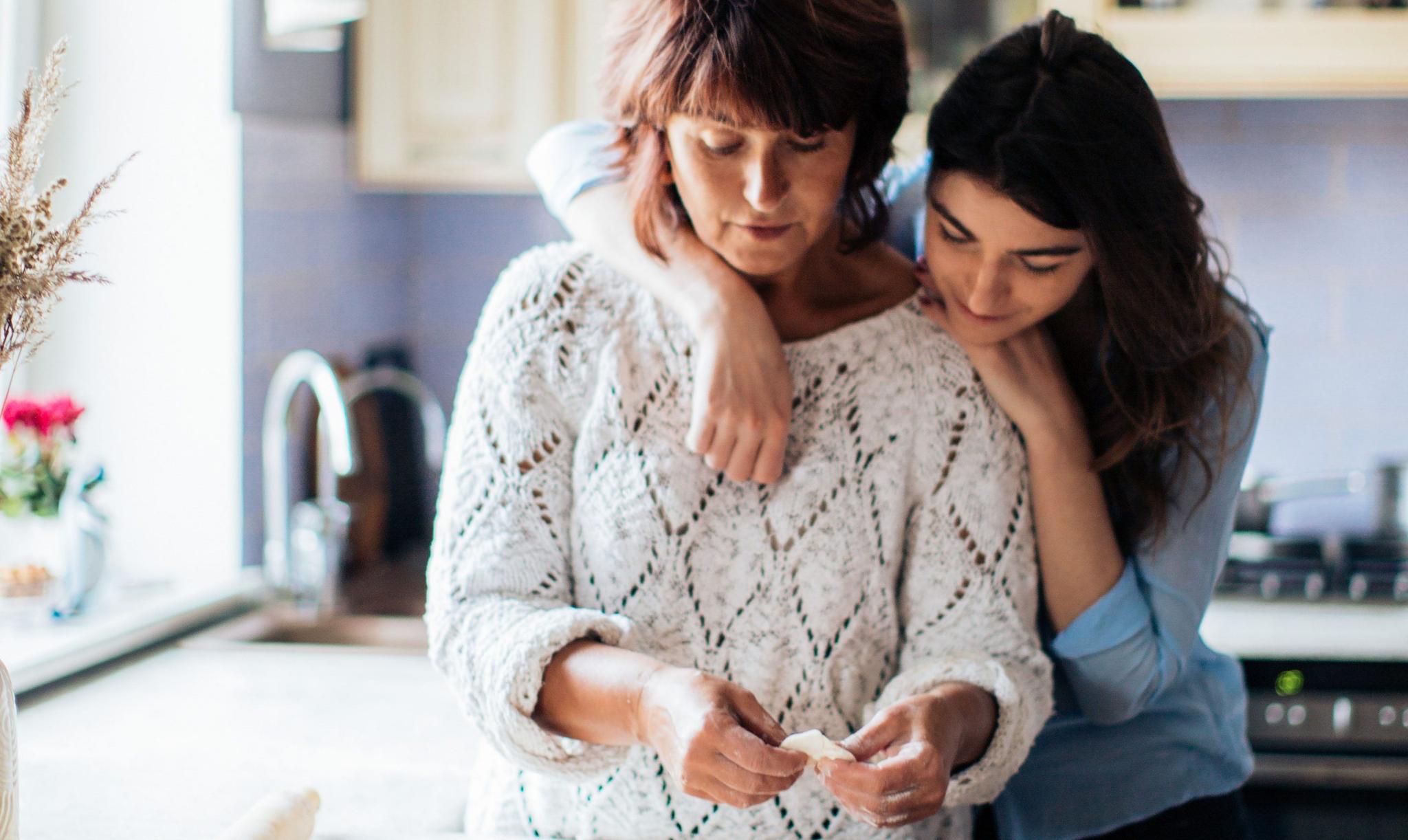 Dos mujeres abrazándose en una cocina.