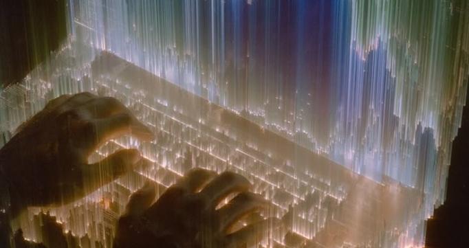 Hands typing on a glowing keyboard beneath green and blue vertical light trails.