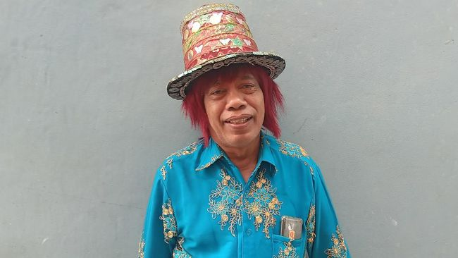 Pak Tarno dengan gigih berjualan ikan cupang dan mainan di depan sekolah dasar di Jakarta