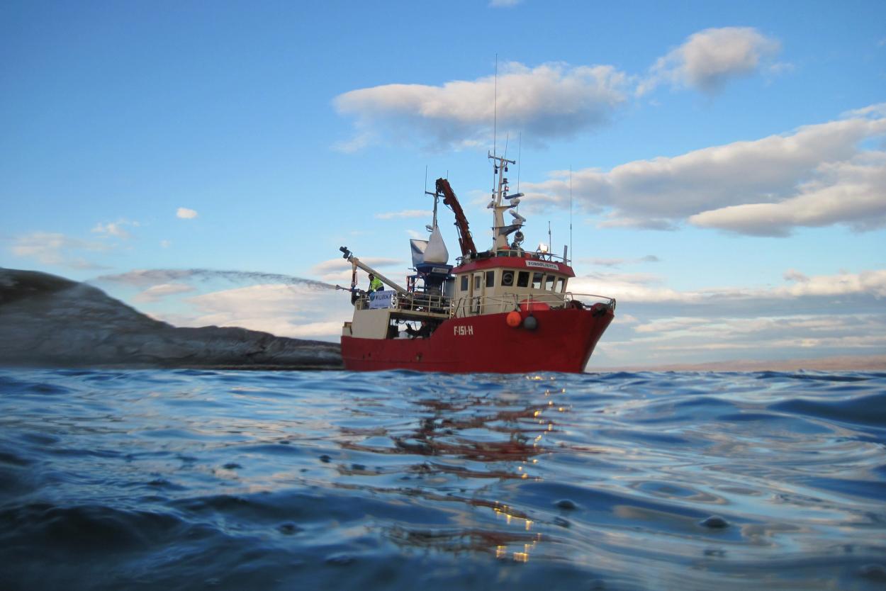 Fishing boat spraying water and quicklime in to the ocean