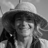 black and white headshot of Lou wearing a hat and smiling