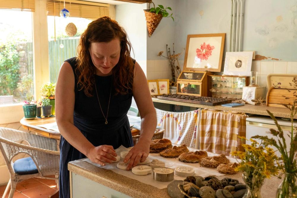 Artist in her studio kitchen with artwork