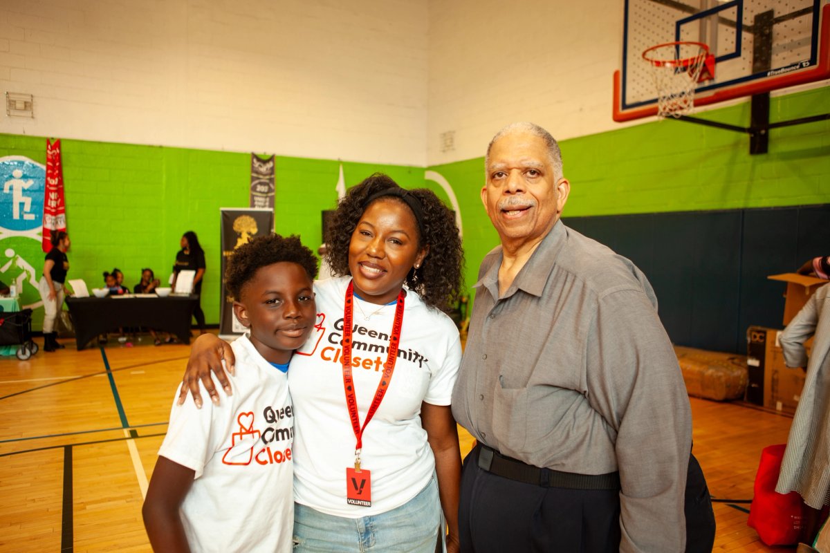 State Senator Leroy Comrie with a Queens Community Closets volunteer and a young attendee at the resource fair