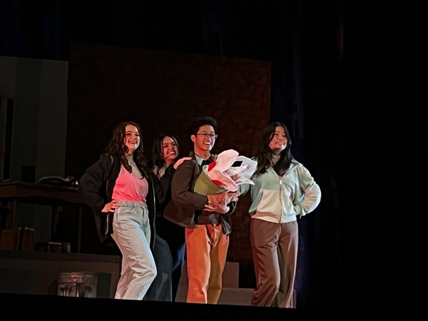 Little Shop of Horrors cast on stage with Audrey II puppet