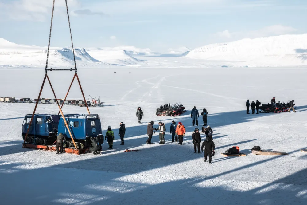 A mobile Arctic film rig being airlifted by crane onto Svalbard’s frozen coastline. PolarX crews use modular logistics platforms and custom-built rigs to execute complex Arctic shoots, even in the most remote polar locations.