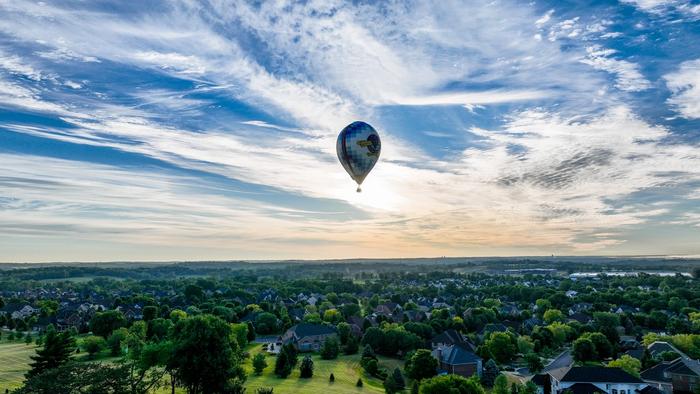 Hot air balloon flying over a park