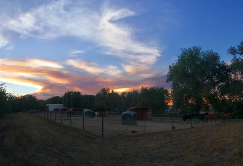 sunset with clouds over looking horse pens