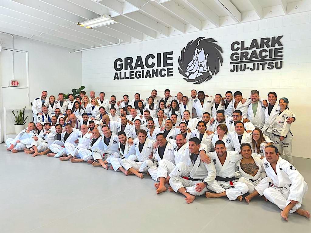 The Clark Gracie Academy team photographed on the mats under the Gracie Allegiance banner