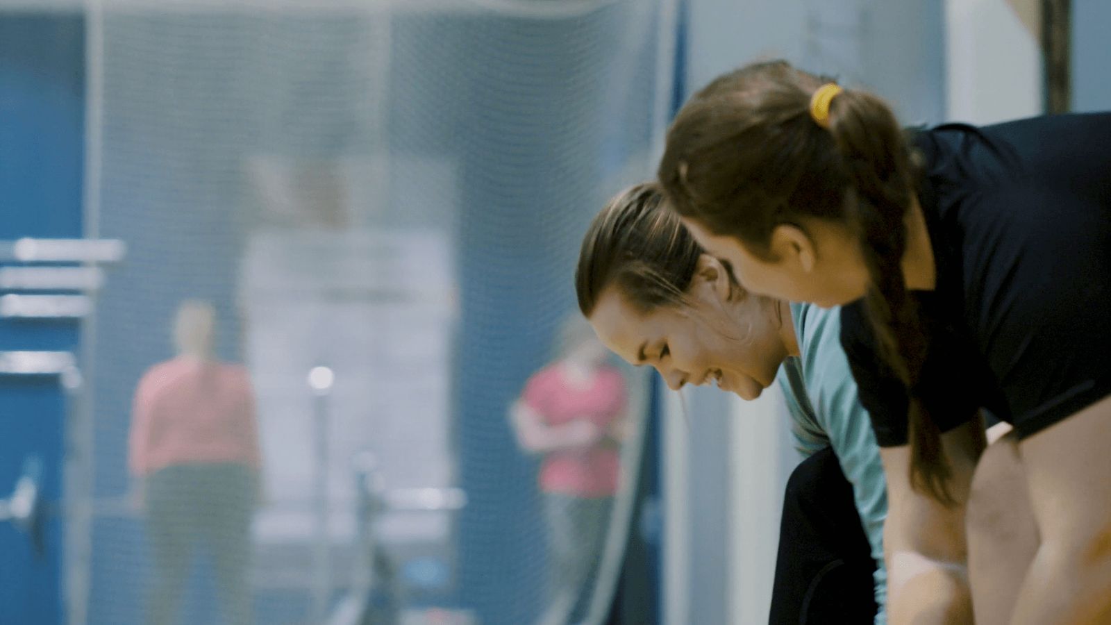 To kvinner snakker sammen i treningshallen