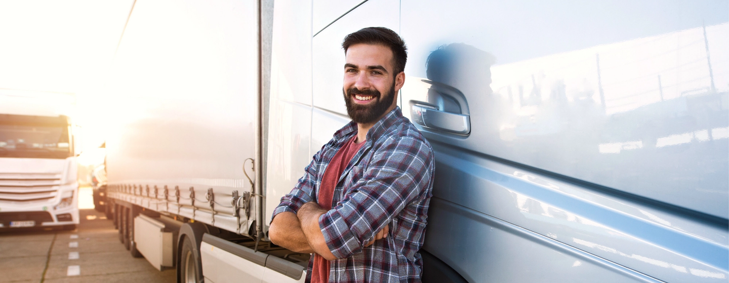 Truck driver in front of his truck smiling because he got easy diabetes care