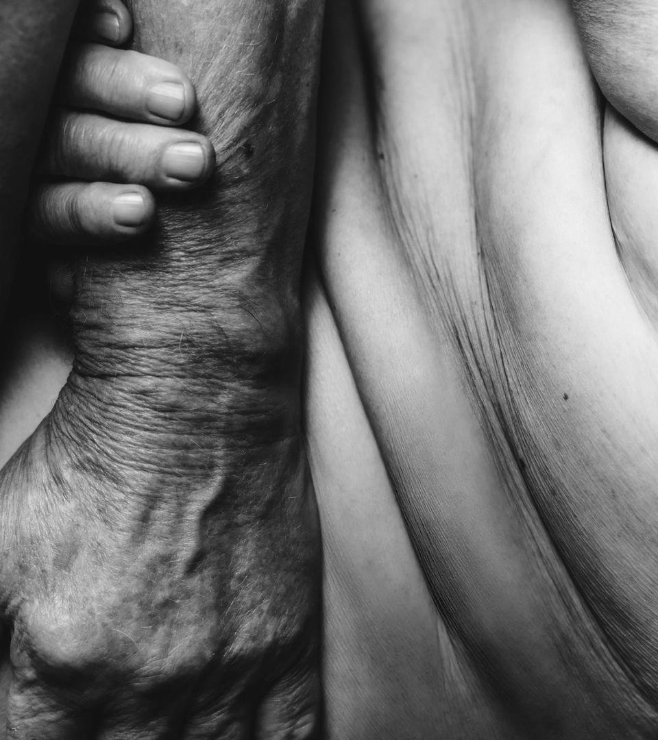 Close-up of hands of elder couple touching each other.