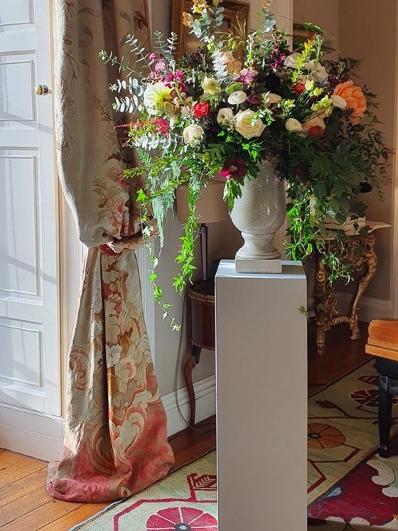 Urn arrangement sits on a plinth at Winton Castle in autumn