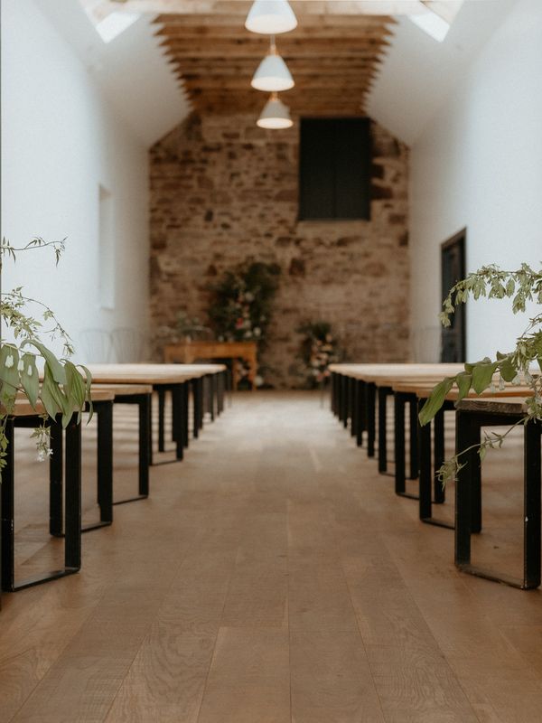 Two urns flank the entrance to the ceremony, with an open arch at the very top of the aisle