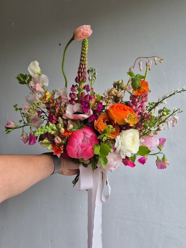Bouquet of locally grown flowers in oranges and pinks